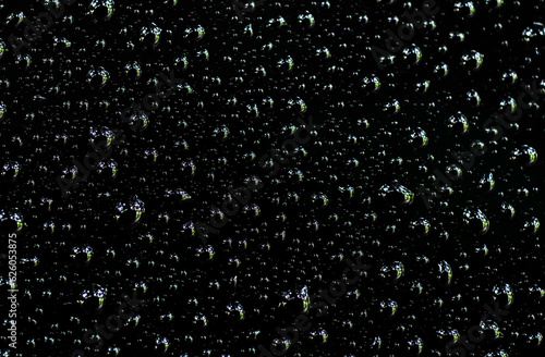 Water droplets on the black glass. Shiny water drops on black surface.