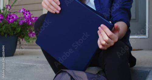 Sad Student Sitting on Steps Outside of a Suburban House
