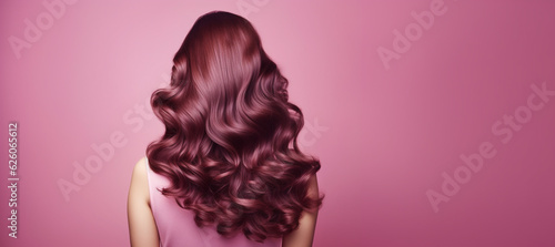 Beautiful young woman with redhead stylish wavy hairdo on pink background, back view