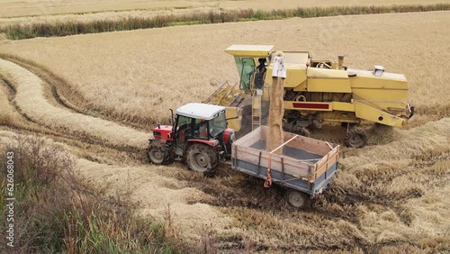 Aerial view combine harvester in corn agrucyktyre field, slow motion photo