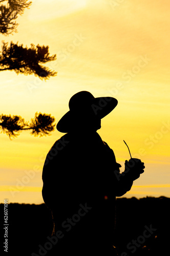 Gaucho man in the backlight, drinking chimarrão in the gourd
