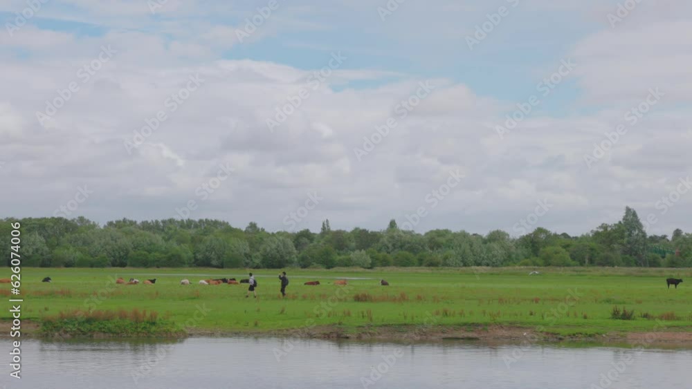 People and dog walking along River Thames next to Port Meadow, Oxford People and dog walking along River Thames next to Port Meadow, Oxford