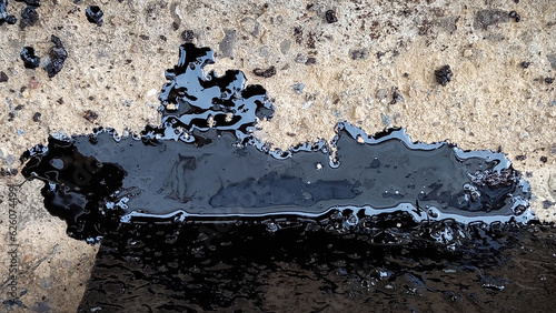 An oil spill occurred near an emergency oil tank with a crack, color image.