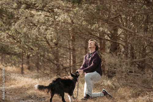 Mature man spending time with his dog in the forest