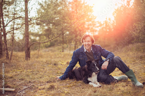 Mature man spending time with his dog in the forest
