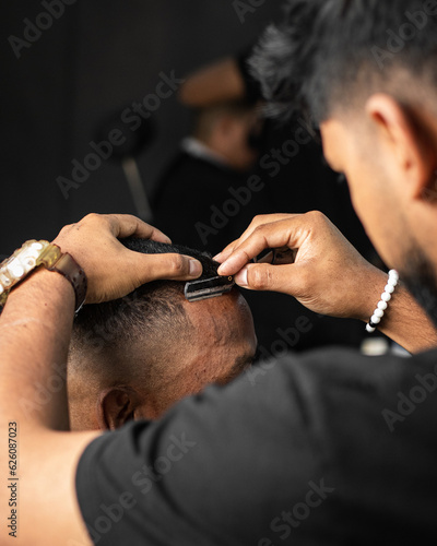 haircut to man with razor in a barbershop