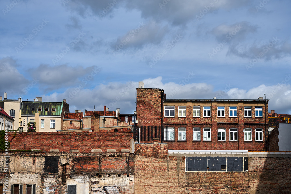 destroyed red brick wall and old tenement houses in Poznan city