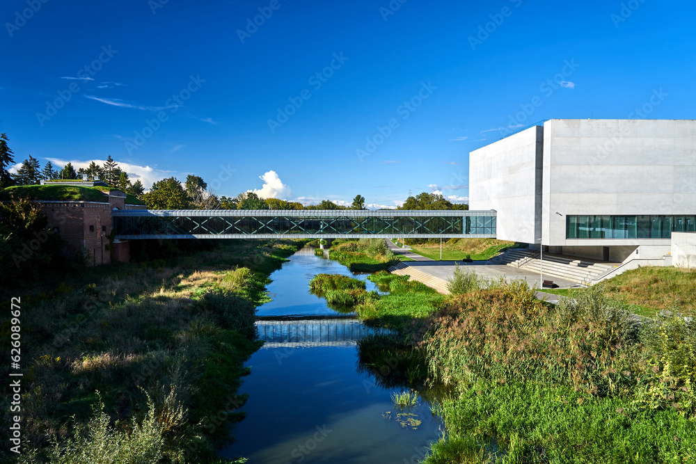 Historic fort building, footbridge and modern building on the Warta river in Poznan - obrazy, fototapety, plakaty 