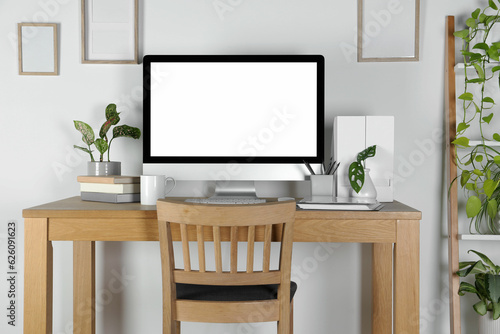 Home workplace. Computer, stationery and houseplants on wooden desk