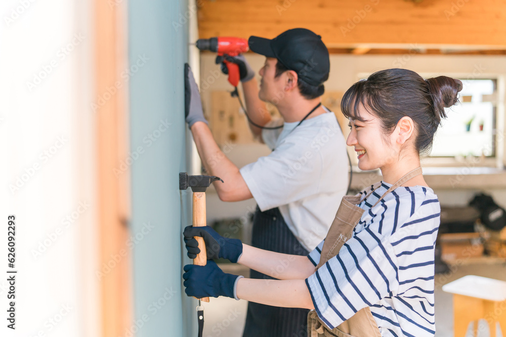 電動ドライバーを使う日本人の男女（DIY）
