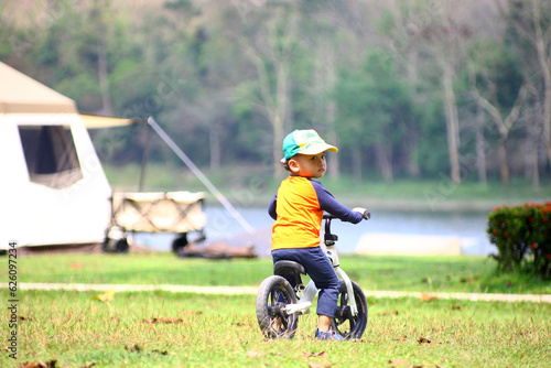 Boy riding balance bike on dirt path in the park
