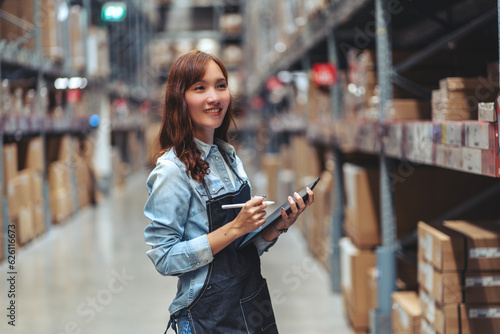 Obraz na płótnie woman Asia walks with a tablet checks stock and view orders to deliver to customers walking in a warehouse at a furniture wholesaler.
w salonie