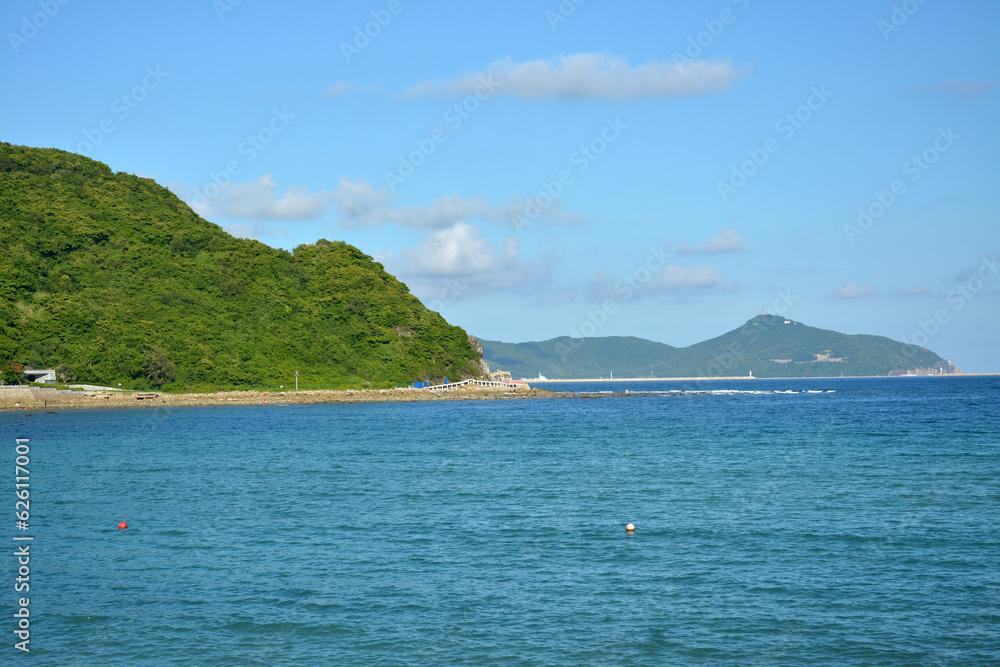 green mountain and blue sea under blue sky in sunny afternoon day
