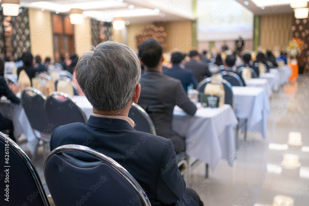 Fototapeta premium Rear view of businessperson participating in a business seminar in the hall