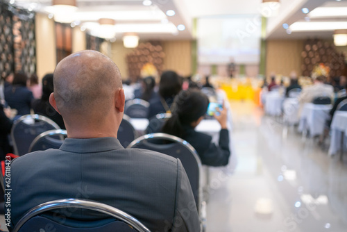 Rear view of businessperson participating in a business seminar in the hall