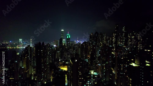 Vol au dessus de la ville de Hong Kong, China, Asie  au milieu des bâtiments et gratte-ciel et au-dessus des tours immenses et de rues illuminées pendant la nuit.