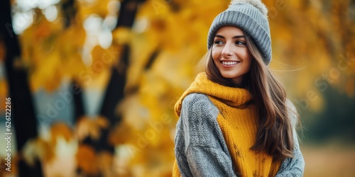  happy woman wearing a cozy clothes against an autumn foliage background