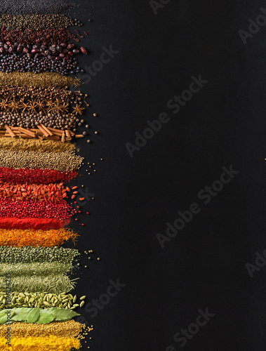 Fototapeta Naklejka Na Ścianę i Meble -  Large collection spices and herbs on background of  black table. Colorful condiments with empty space for text or label.