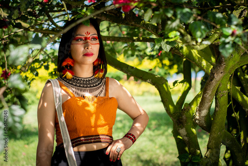 beautiful young peruvian woman of the yanesha culture posing with dresses, jewelry, makeup, clothes and accessories designed with Asháninka iconography in nature