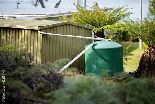 Plastic water tank in the forest of an off grid house in Australia photo