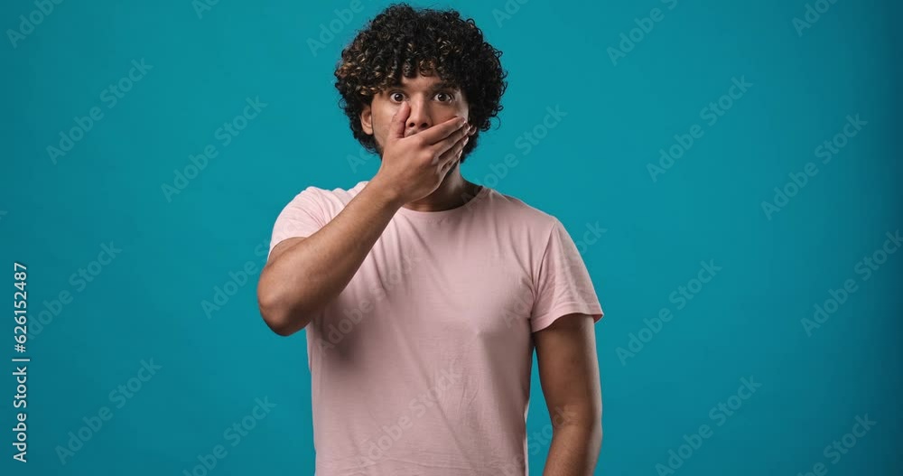 Amazed indian man shocked saying WOW surprised to camera standing isolated over blue studio background Amazed indian man shocked saying WOW surprised to camera standing isolated over blue studio background