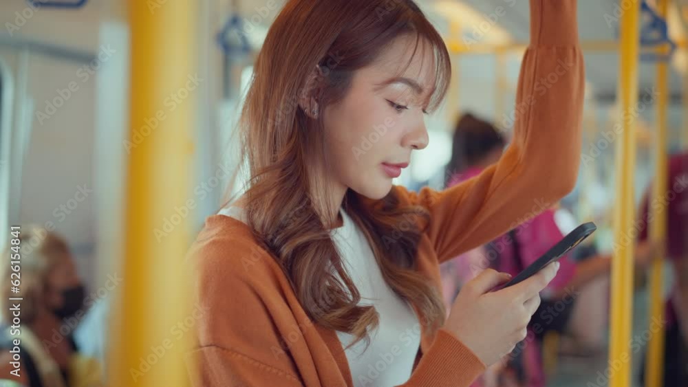 Happy asian woman using smartphone watching a live stream on the train, Smile passengers on a subway using social media on their mobile phone. Happy asian woman using smartphone watching a live stream on the train, Smile passengers on a subway using social media on their mobile phone.