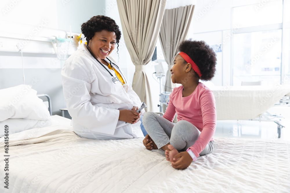 Happy african american female doctor talking to girl patient at hospital Happy african american female doctor talking to girl patient at hospital