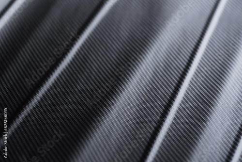 Carbon fiber composite raw material background. Carbon fiber texture. Dark Gray background with lighting.