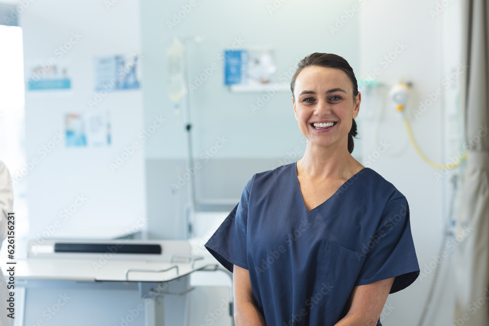 Portrait of happy caucasian female doctor wearing blue scrubs at hospital, copy space Portrait of happy caucasian female doctor wearing blue scrubs at hospital, copy space