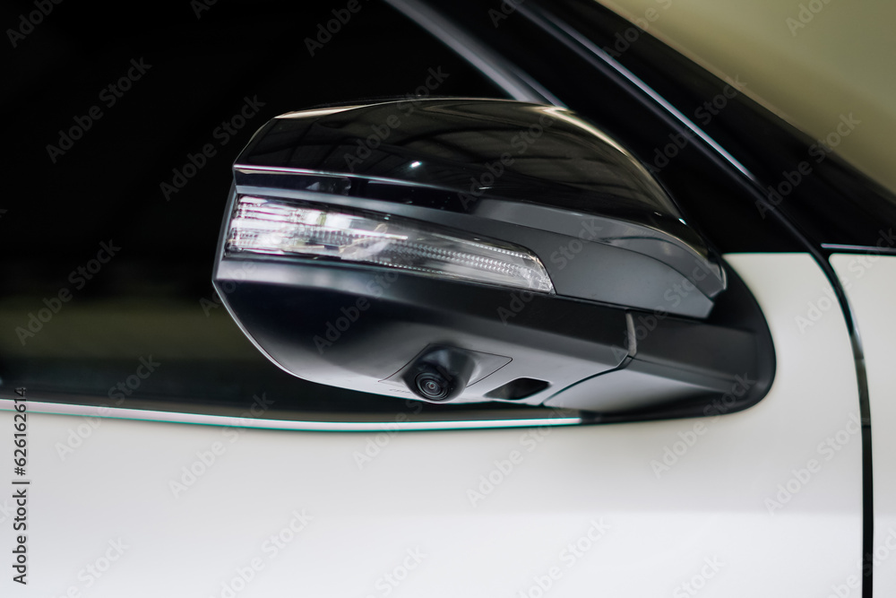 Close-up the wing mirror with camera of the white car