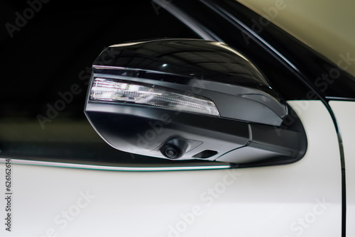 Close-up the wing mirror with camera of the white car