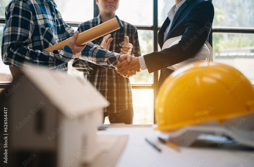 Engineer desk with object paper and tablet with blurry engineer teamwork hardworking to consults about their building project. Engineer desk with object paper and tablet with blurry engineer teamwork hardworking to consults about their building project.
