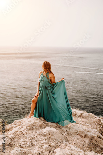 Woman sea trevel green dress. Side view a happy woman with long hair in a long mint dress posing on a beach with calm sea bokeh lights on sunny day. Girl on the nature on blue sky background.