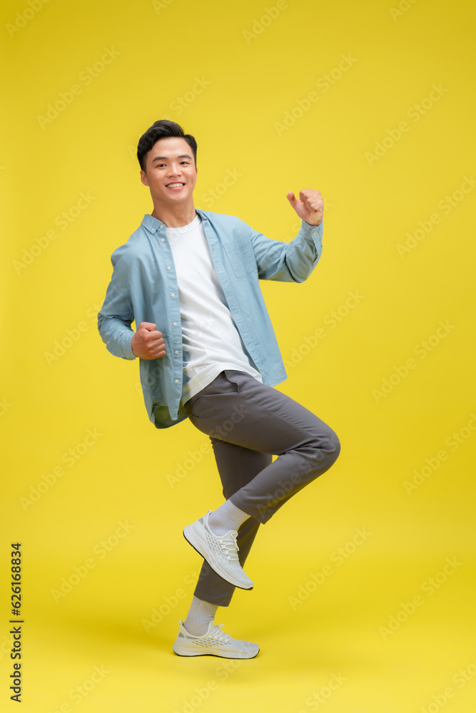 Young man very happy and excited doing winner gesture with arms raised,
