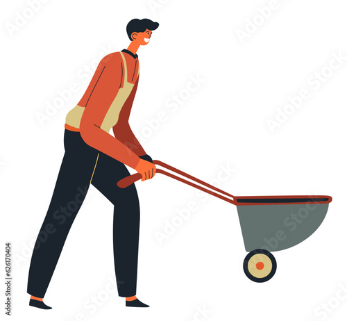 Worker pushing wheelbarrow at construction site
