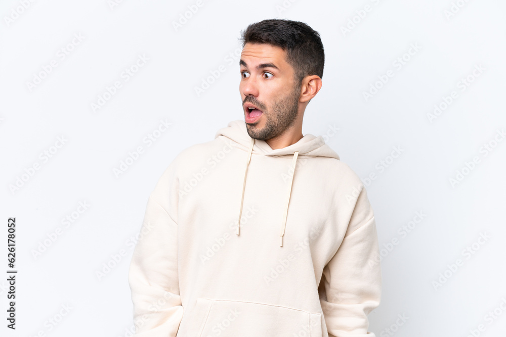 Young caucasian man isolated on white background doing surprise gesture while looking to the side Young caucasian man isolated on white background doing surprise gesture while looking to the side