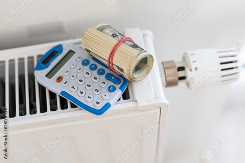 Fototapeta Naklejka Na Ścianę i Meble -  calculator and money on heating radiator with temperature regulator