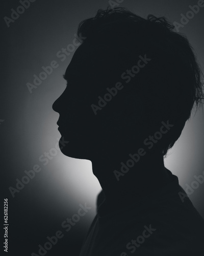 Silhouette of a man in distress in a dark room