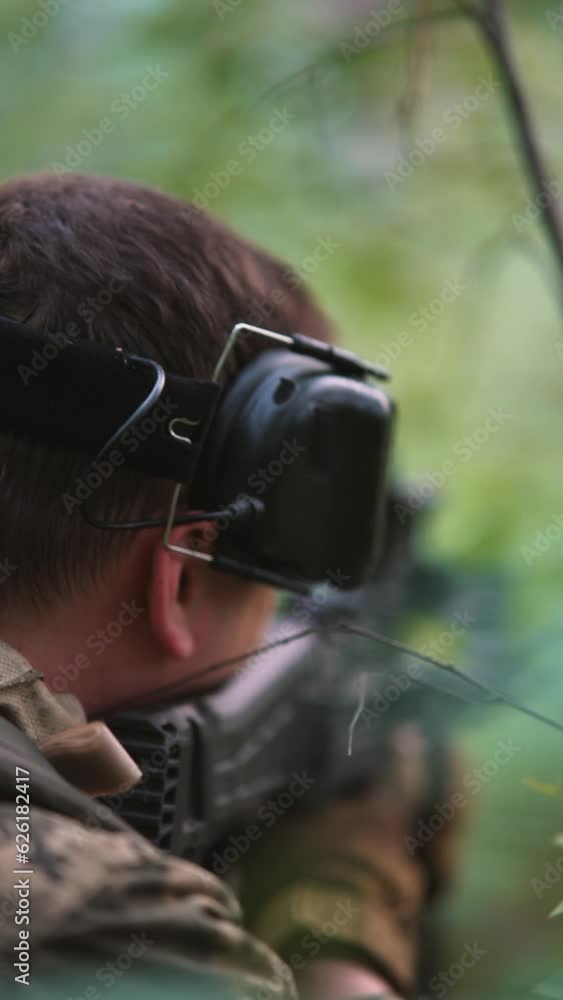 image of a military soldier positioned in a forest, gripping a firearm with their hands and peering intently through the scope. image of a military soldier positioned in a forest, gripping a firearm with their hands and peering intently through the scope.