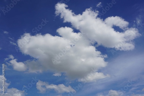 A blue sky background with cumulus white clouds in the sky.