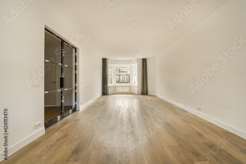 an empty living room with wood flooring and white walls in the room is well lit by light from the window © Casa imágenes