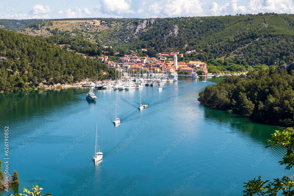 Fototapeta premium Skradin, Croatia. 06-08-2023.Boats leaving the port of Skradin. View of the rest area from the highway.