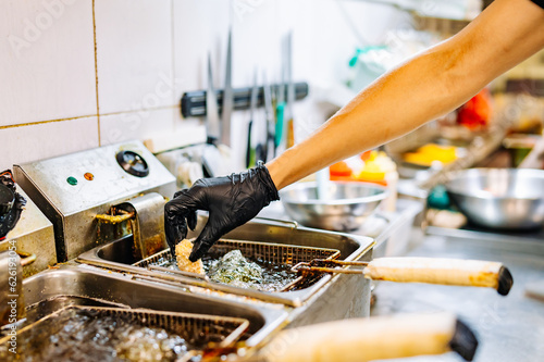 Close up image of cooking chicken nugget tempura in deep fry on kitchen