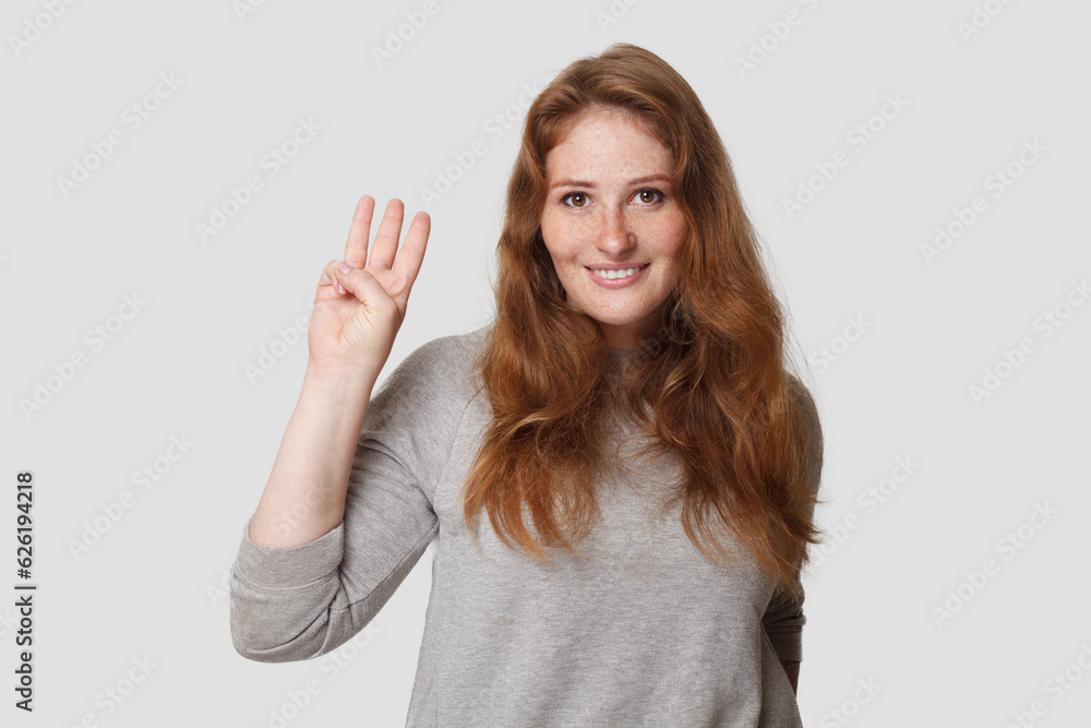 Young happy woman showing three finger on white background Young happy woman showing three finger on white background