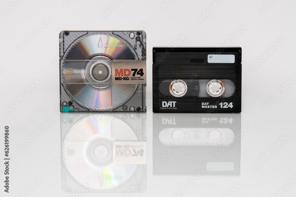 A minidisc shimmering with iridescent reflections and a DAT cassette