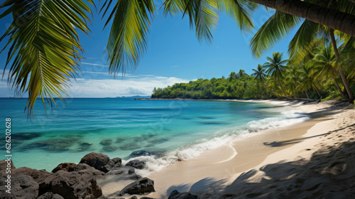 A picturesque view of a white sandy beach and a tranquil turquoise sea, framed by vibrant green palm trees.