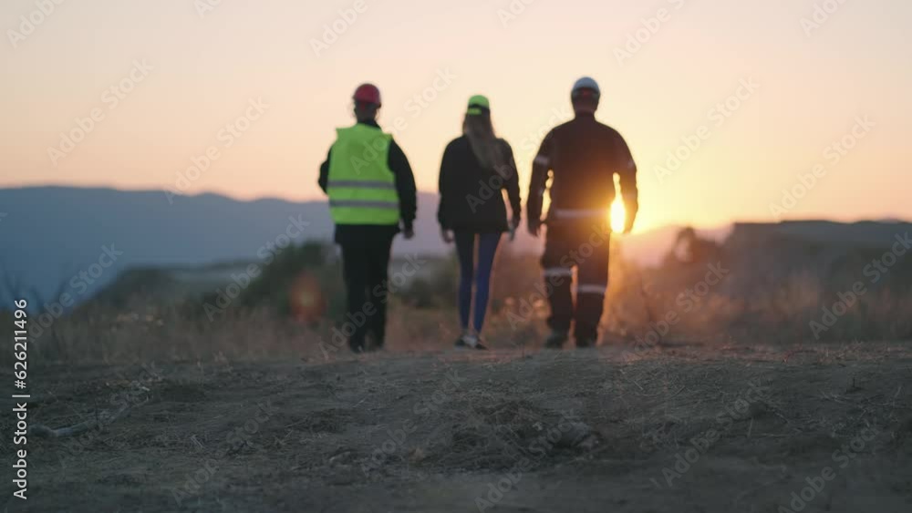 Unrecognizable team of successful engineers check new construction location at sunset, sunrise, slow motion