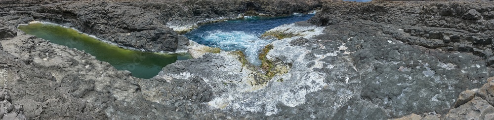Sea colourful natural pools in black rocks during summer in buracona, the blue eye cave of Cape verde, in sal island