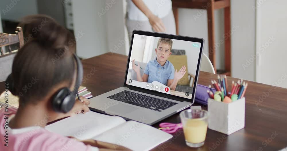 Diverse schoolgirl having class on laptop video call with her friend in slow motion Diverse schoolgirl having class on laptop video call with her friend in slow motion