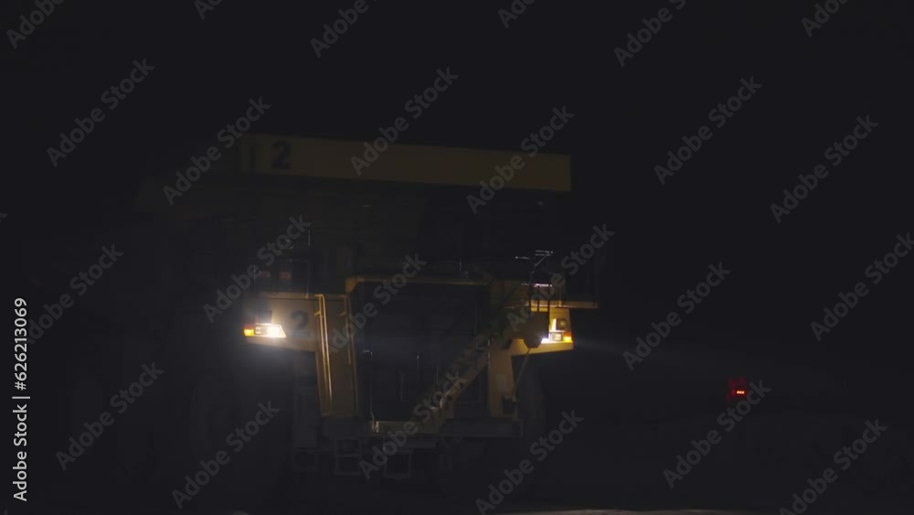 Dust raised by a dump truck transporting ore in a copper mine at night, slow motion Dust raised by a dump truck transporting ore in a copper mine at night, slow motion